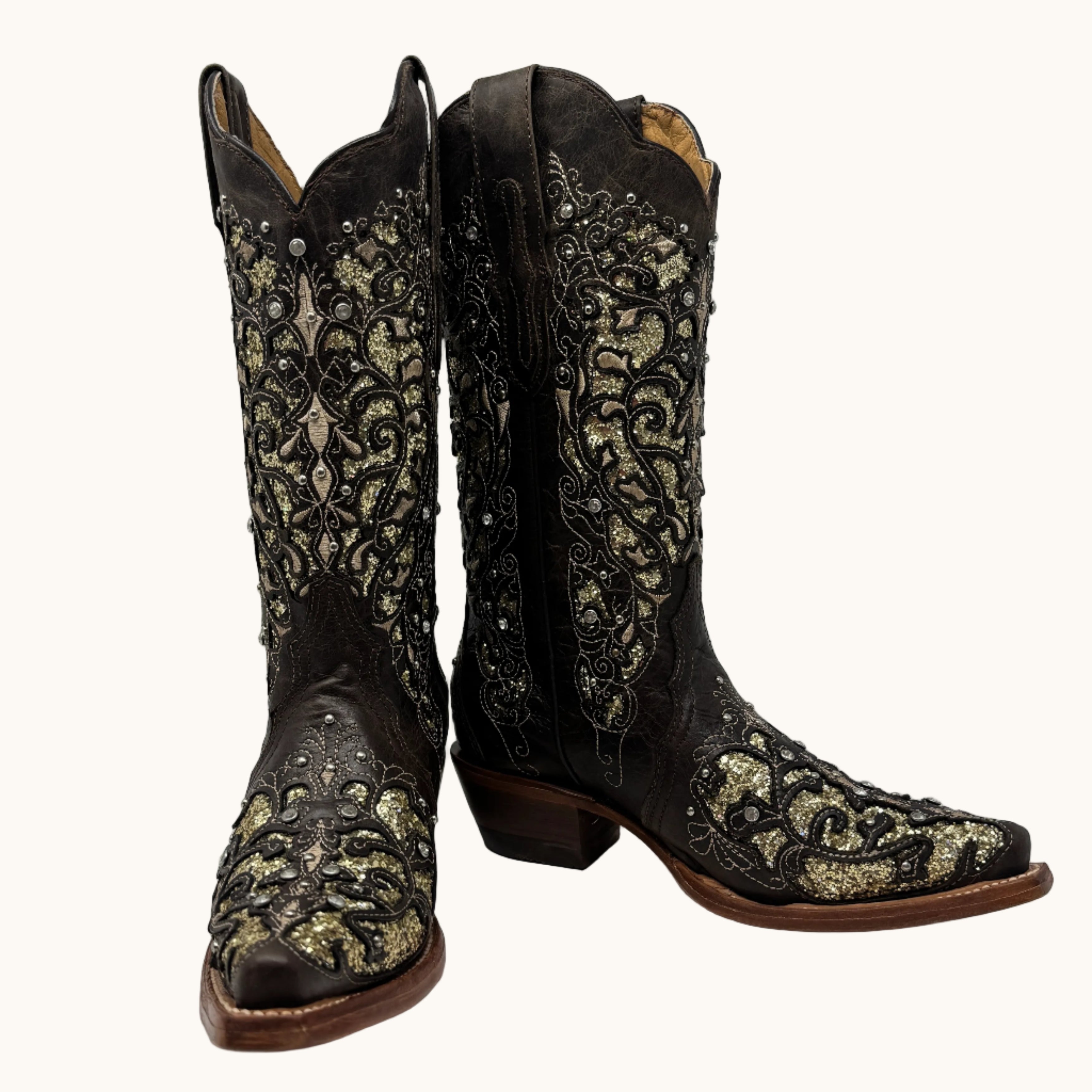 Pair of black and gold embroidered cowboy boots on a white background